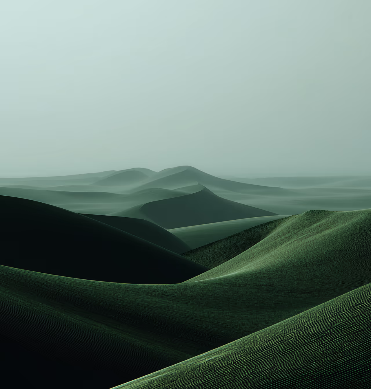Rolling green sand dunes fading into a misty, pale green sky.